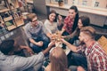 Cheers! Group of multiethnic friends sitting on couch with drinks