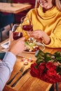 Cheers for happiness. Close-up of couple holding red wine in restaurant Royalty Free Stock Photo