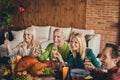 Cheers. Thanks giving family meeting four aged members listen greeting toast drink golden wine raise glasses living room