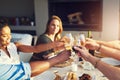 Cheers to many more years of friendship. a group of friends raising up their glasses for a toast while sitting around a Royalty Free Stock Photo