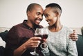 Cheers to many more years of loving you. a happy young couple drinking wine and relaxing together at home. Royalty Free Stock Photo