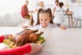 Cheery little girl looking at roasted Thanksgiving or Christmas turkey, cannot wait for holiday family dinner to start Royalty Free Stock Photo