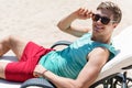 Cheery youthful man having rest on resort outdoor