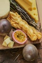 Cheese assorted on a wooden board with herbs and fruits.Hard and soft cheeses, rosemary and passion fruit. Mazdar cheese Royalty Free Stock Photo