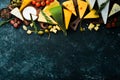 Cheese. Assortment of cheese and snacks on black stone background. Top view. Royalty Free Stock Photo