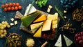Cheese. Assortment of cheese and snacks on black stone background. Top view. Royalty Free Stock Photo