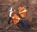 Cheese and bacon croissant on a wooden cutting board with knife Royalty Free Stock Photo