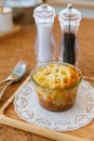 Cheese Baked Penne in glass bowl on wooden plate with salt, pepper and cutlery Royalty Free Stock Photo