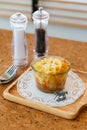 Cheese Baked Penne in glass bowl on wooden plate with salt, pepper, cutlery and miniature horse model Royalty Free Stock Photo