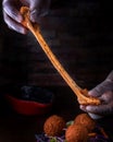 Cheese Balls holding in hand with dip, onion, carrot and lettuce leaf served in dish isolated on wooden table side view of arabic Royalty Free Stock Photo