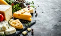 Cheese on black board with spices on rustic background Royalty Free Stock Photo