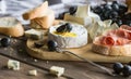 cheese board grapes and baguette. Assortment of cheese with berries on wooden background. Royalty Free Stock Photo