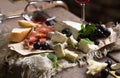 Cheese board grapes and baguette. Assortment of cheese with berries on wooden background. Royalty Free Stock Photo