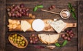 Cheese board. Various types of cheese. Cheese plate with cheeses Parmesan, Brie, Camembert and Roquefort  serving with grapes, Royalty Free Stock Photo