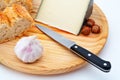 Cheese, bread, hazelnuts and knife on wood plate Royalty Free Stock Photo