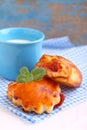 Cheese buns with cherry jam. Blue cup with milk Royalty Free Stock Photo