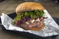 Cheese burger with blue cheese, onions and cabbage crisps over stone background