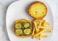 cheese burger top with pickles and relish served with fries