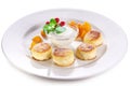 Cheese cakes with sour cream, slices of sweet peach, mint and red currants on a white plate. Clipping path