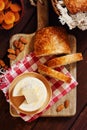 Cheese camembert or brie with bagette, nuts and dried apricots served on wooden board from above