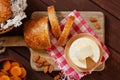 Cheese camembert or brie with bagette, nuts and dried apricots served on wooden board from above