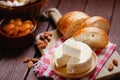 Cheese camembert or brie with bagette, nuts and dried apricots served on wooden board