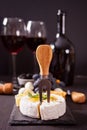 Cheese camembert brie on the board, two glasses and bottle of red wine Royalty Free Stock Photo