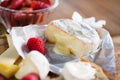 Cheese camembert and fruit on wooden kitchen board. Royalty Free Stock Photo