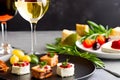 Cheese canapes on black plate with wine glass. Generative AI