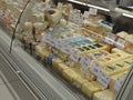Cheese cheeses on super market front store prices labes on it , glass protective front