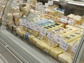 Cheese cheeses on super market front store prices labes on it , glass protective front