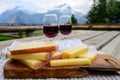 Cheese collection, French comte, beaufort or abondance cow milk cheese and glasses of red wine from Savoie served outdoor with Royalty Free Stock Photo