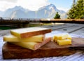 Cheese collection, French comte, beaufort or abondance cow milk cheese served outdoor with Alps mountains peaks on background Royalty Free Stock Photo