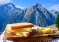 Cheese collection, French comte, beaufort or abondance cow milk cheese served outdoor with Alps mountains peaks on background Royalty Free Stock Photo