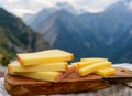 Cheese collection, French comte, beaufort or abondance cow milk cheese served outdoor with Alps mountains peaks on background Royalty Free Stock Photo