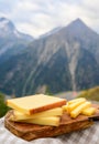 Cheese collection, French comte, beaufort or abondance cow milk cheese served outdoor with Alps mountains peaks on background Royalty Free Stock Photo