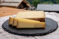 Cheese collection, French cow cheese comte, beaufort, abondance and french mountains village in Haute-Savoie on background Royalty Free Stock Photo