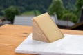 Cheese collection, French cow cheese comte, beaufort, abondance and french mountains village in Haute-Savoie on background Royalty Free Stock Photo