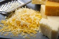 Cheese collection, matured and orange original British cheddar cheese in blocks and grated served on grey plate