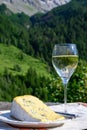 Cheese collection, piece of French Alps mountains blue cheese BLEU DE SAVOIE served with white wine outdoor in French Alps