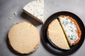 Cheese collection, variety of cheeses with tomatoes on wooden background. Generative AI