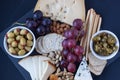 Cheese, crackers, grape, nuts on a black background Royalty Free Stock Photo