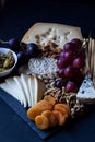 Cheese, crackers, grape, nuts on a black background Royalty Free Stock Photo