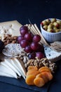 Cheese, crackers, grape, nuts on a black background Royalty Free Stock Photo