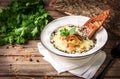 Cheese cream soup with porcini mushrooms, fried onion rings and sesame seeds, garnished with parsley in a white plate on a rustic