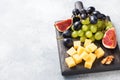 Cheese cubes, fresh fruit figs grapes Honey walnut on wooden chopping Board. Copy space Royalty Free Stock Photo