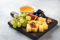 Cheese cubes, fresh fruit figs grapes Honey walnut on wooden chopping Board. Copy space Royalty Free Stock Photo