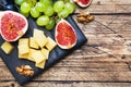 Cheese cubes, fresh fruit figs grapes Honey walnut on wooden chopping Board. Copy space. Royalty Free Stock Photo