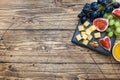 Cheese cubes, fresh fruit figs grapes Honey walnut on wooden chopping Board. Copy space Royalty Free Stock Photo