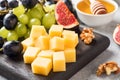 Cheese cubes, fresh fruit figs grapes Honey walnut on wooden chopping Board. Selective focus. Close up Royalty Free Stock Photo